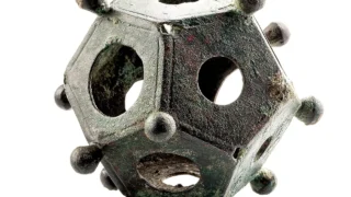 A Roman bronze dodecahedron with openings and corner knobs.